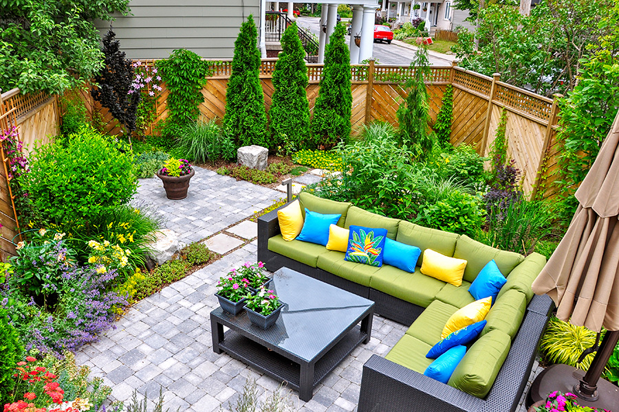 A beautiful small, urban backyard garden - paved stone patio with outdoor room furniture and lots of greenery - Lebanon, IL